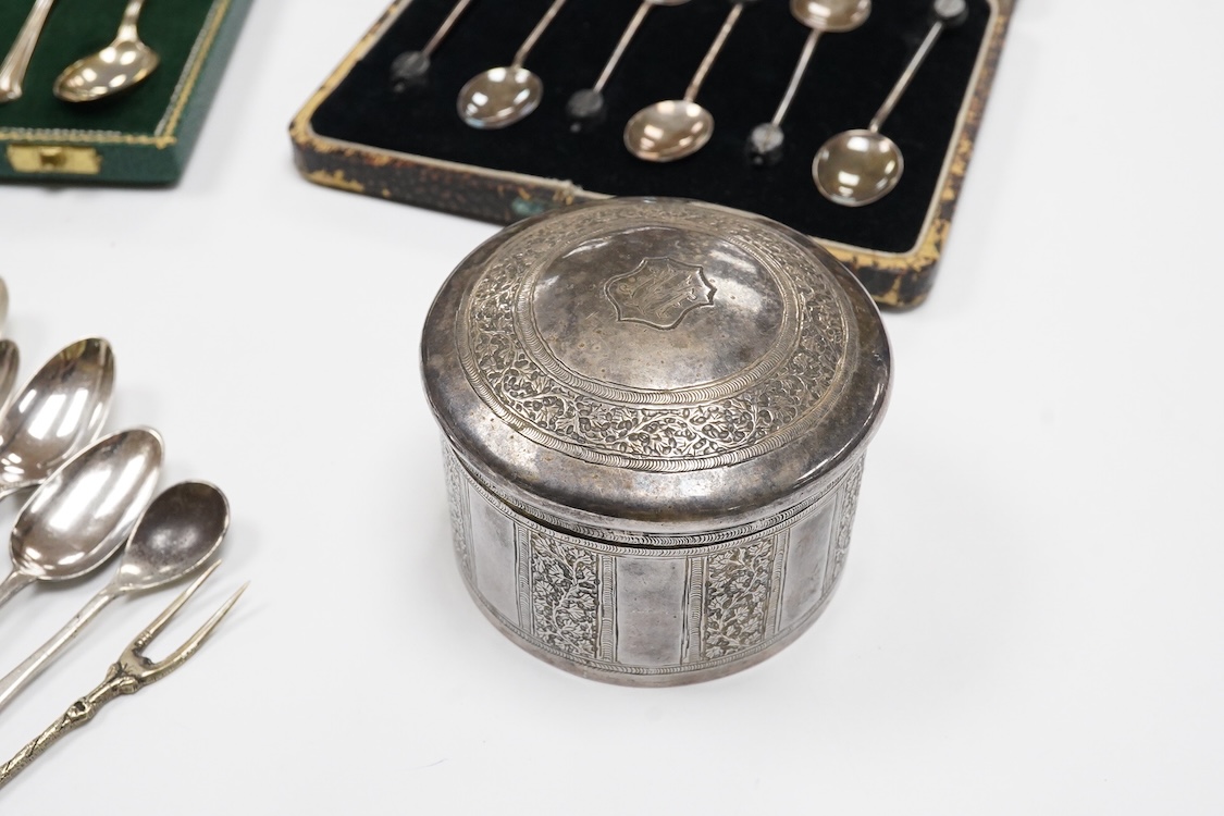 A collection of silver and white metal to include a 19th century Indian dressing table pot and cover chased with flowers, a three piece silver condiment set by Mappin and Webb with associated condiment spoon, three cased